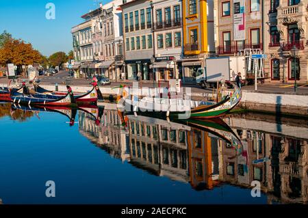 Traditionelle bunte Boote (Barcos moliceiros Ursprünglich für das Sammeln von Algen verwendet) in den ruhigen Wasser des Kanals zentral in Aveiro, Po widerspiegelt Stockfoto