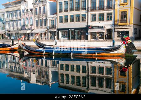 Traditionelle bunte Boote (Barcos moliceiros Ursprünglich für das Sammeln von Algen verwendet) in den ruhigen Wasser des Kanals zentral in Aveiro, Po widerspiegelt Stockfoto