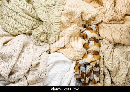 Viele gestrickte Winter Pullover in einem Haufen aufgetürmt. Zusammenfassung Hintergrund von Winterbekleidung Stockfoto