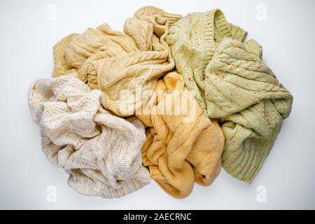 Stapel der gestrickte Pullover auf weißem Hintergrund Stockfoto