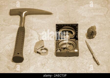 Die Werkzeuge der Geologe auf einer topographischen Karte. Hintergrund. Toning. Stockfoto