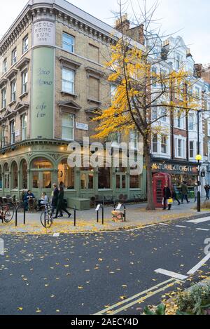 Menschen heraus und über an einem Samstag außerhalb der Coco Momo Café, Bar und Bistro in der Marylebone High Street, London, England, Großbritannien Stockfoto