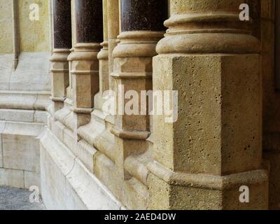 Helle farbe porösen Stein Spalte Base und dunklen glänzenden glatten dekorative Säulen, der auf den Boden der Kirche Eingang. alte Architektur Konzept. Stockfoto