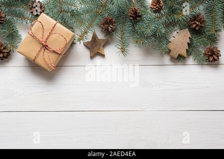 Weihnachten Rahmen von tannenzweigen, Geschenke und Holzspielzeug auf weißem Holzbrett. Ansicht von oben. Platz für Text Stockfoto