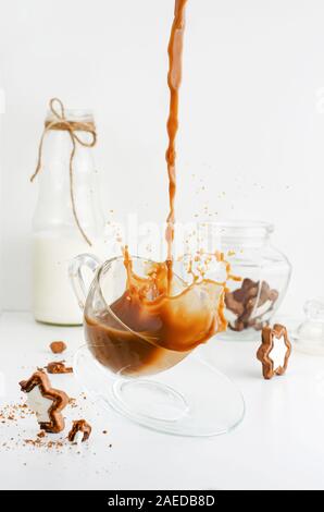 Gießen Kaffee mit Splash in einem transparenten Cup auf weißem Hintergrund. Vertikale Stockfoto