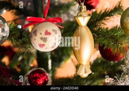 Golden Christmas ornament am Weihnachtsbaum. Bunter Hintergrund. Weihnachten und neues Jahr Dekoration. Stockfoto