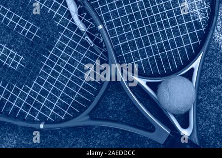 Oben Ansicht von zwei Tennisschläger mit dem Ball auf dem Boden des Hofes im Freien Konzept Stockfoto