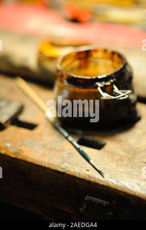 Geigenbaumeister lackiert eine handgefertigte Geigensaiten-Laute als letzten Schliff, um seine Schöpfung in seiner Werkstatt in Cremona, Lombardei, zu beenden Stockfoto