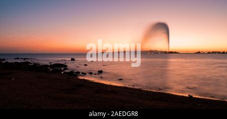 Panoramablick auf die König Fahd's Fountain aus dem Süden Corniche, Jeddah, Saudi Arabien gesehen, mit einem wunderschönen Sonnenuntergang im Hintergrund Stockfoto