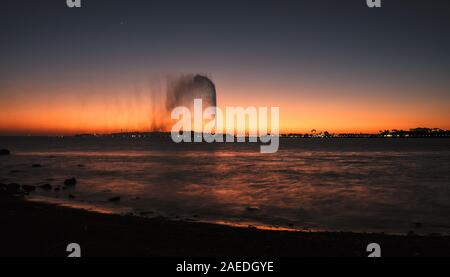 Panoramablick auf die König Fahd's Fountain aus dem Süden Corniche, Jeddah, Saudi Arabien gesehen, mit einem wunderschönen Sonnenuntergang im Hintergrund Stockfoto