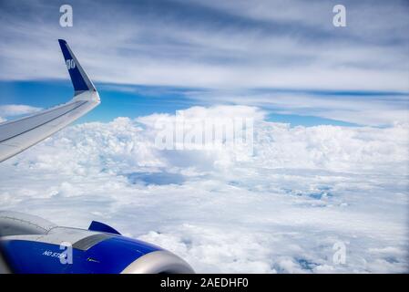 Blick aus dem Flugzeug mit weißen Wolken und blauer Himmel Stockfoto