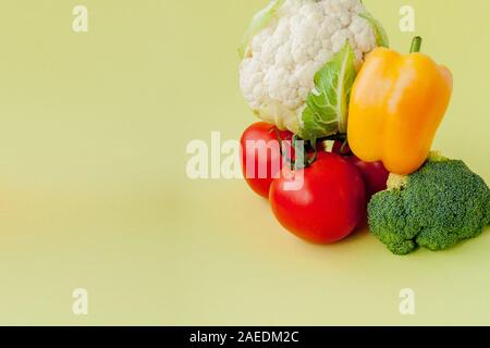 Gesunde, saubere Essen Layout, vegetarisches Essen und Ernährung Ernährung Konzept. Verschiedene frische Gemüse Zutaten für Salat auf gelbe Tabelle Hintergrund Stockfoto