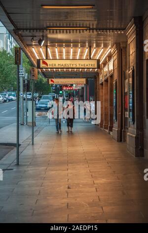 Melbourne, Australien - 15. November 2009: Paar Spaziergänge unter dem Festzelt vor der beleuchteten Eingang zu ihrem Majestys Theatre. Dominante braune Farben ein Stockfoto