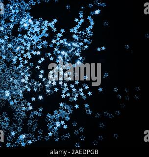 Classic blau Farbe 2020 Konzept. Splash von glänzenden silbernen Sterne auf einem schwarzen Hintergrund. Stockfoto