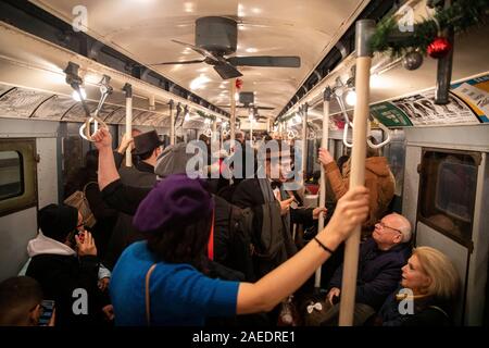 New York, USA. 8 Dez, 2019. Die Menschen nehmen eine Fahrt in einem Oldtimer u-bahn Auto während Urlaub Nostalgie Fahrgeschäfte in der New Yorker U-Bahn, den Vereinigten Staaten, 8. Dezember, 2019. Jeden Sonntag zwischen Thanksgiving und Neues Jahr, Vintage 1930 s R 1-9 Waggons regelmäßig in New York City U-Bahn Service auf bestimmten Strecken während der jährlichen Urlaub Nostalgie Fahrgeschäfte platziert werden würde, wobei die Passagiere zurück in alte Zeiten. Credit: Wang Ying/Xinhua/Alamy leben Nachrichten Stockfoto