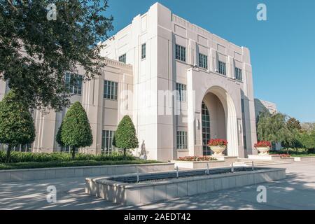 Historische Winter Garden City Hall in Florida. Ein weißes 3stöckiges Gebäude aus Stein mit roten Blumen, Brunnen vor der Tür. Stockfoto