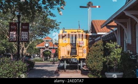 WINTER GARDEN, Florida: 29. Mai 2019 - Historische gelbe Eisenbahn Auto vor dem Clock Tower und neben dem Heritage Museum in der Innenstadt liegt. Stockfoto