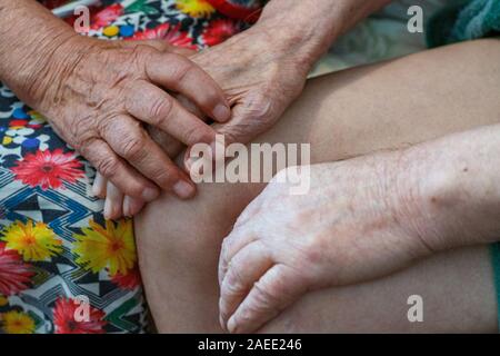 Ältere Mann und Frau halten Hände mit Liebe. Großeltern halten einander die Hände. Rentner, die in einem Pflegeheim sind langweilig. Stockfoto