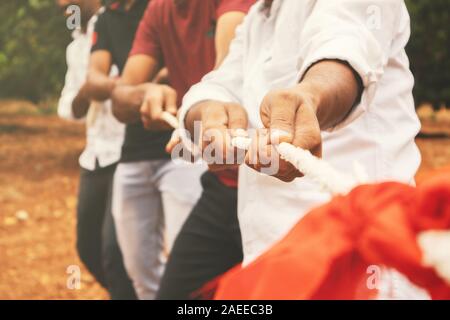 Nahaufnahme von Händen spielen Tauziehen - Gruppe von Freunden spielen Spiele im Freien im Wandel der digitalen und Technologie weltweit. Stockfoto