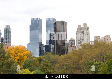 Skyline Gebäuden rund um den Central Park in New York City. Blick aus dem Park durch Bäume. Stockfoto