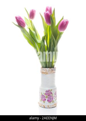 Fünf lila Tulpen in einer dekorativen Vase auf einem weißen Hintergrund mit Reflexion. Valentinstag und Tag der Frauen Konzept Stockfoto