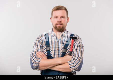 Bärtige Techniker oder Handwerker in Shirt und Overalls holding Hammer Stockfoto