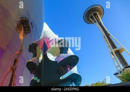 Die Space Needle gegen den klaren blauen Himmel reflektiert über das Museum der Popkultur (Mopop) Fassade im Zentrum von Seattle, Seattle, Washington, USA. Stockfoto