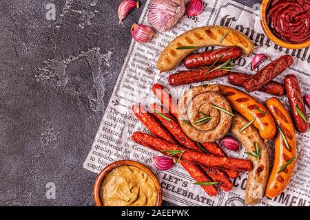 Hausgemachte Wurst vom Grill auf eine Zeitung, Ansicht von oben. Stockfoto