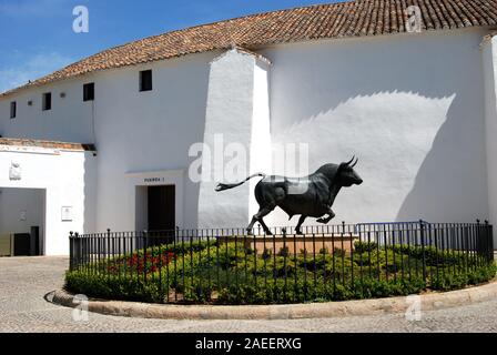 Stier Statue in ein Blumenbeet mit der stierkampfarena an der Rückseite, Ronda, Provinz Malaga, Andalusien, Spanien, Europa. Stockfoto