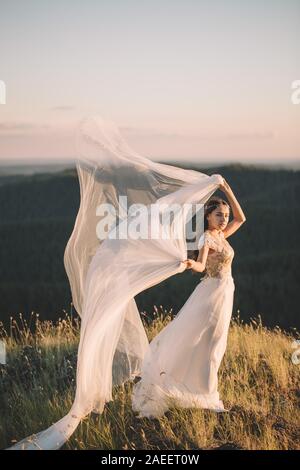 Schöne Braut Frau in weißem Kleid auf dem Feld, im Freien im Sommer. Bildende Kunst, Hochzeit, Glück, Leben, Liebe, Leben Konzept Stockfoto