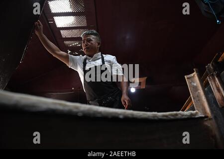 (191209) - JINGXIAN, Dez. 9, 2019 (Xinhua) - Cao Jianqin macht Xuan Papier an der Zijinlou Xuan Papier Fabrik in Jingxian Grafschaft, Stadt Xuancheng der ostchinesischen Provinz Anhui, Okt. 22, 2019. Xuan Papier, traditionelle Chinesische Papier in Jingxian Grafschaft Xuancheng Stadt gemacht, hat eine Geschichte von mehr als 1.000 Jahren. Durch über 100 Verfahren, der das Papier kostet mindestens ein Jahr das Material in das endgültige Produkt zu machen. Für den "Distinguished Handwerk bekannt, feine Qualität und lange Zeit zu bewahren, das Papier ist von chinesischen Künstlern und Kalligraphen geliebt und heißt 'Papier mit li Stockfoto