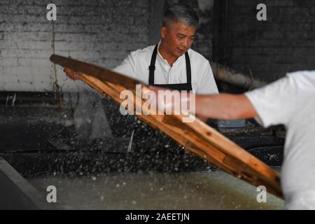 (191209) - JINGXIAN, Dez. 9, 2019 (Xinhua) - Cao Jianqin macht Xuan Papier an der Zijinlou Xuan Papier Fabrik in Jingxian Grafschaft, Stadt Xuancheng der ostchinesischen Provinz Anhui, Okt. 22, 2019. Xuan Papier, traditionelle Chinesische Papier in Jingxian Grafschaft Xuancheng Stadt gemacht, hat eine Geschichte von mehr als 1.000 Jahren. Durch über 100 Verfahren, der das Papier kostet mindestens ein Jahr das Material in das endgültige Produkt zu machen. Für den "Distinguished Handwerk bekannt, feine Qualität und lange Zeit zu bewahren, das Papier ist von chinesischen Künstlern und Kalligraphen geliebt und heißt 'Papier mit li Stockfoto