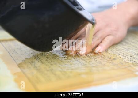 (191209) - JINGXIAN, Dez. 9, 2019 (Xinhua) - Cao Jianqin Reparaturen Seiten eines alten Buches Zijinlou Xuan Papier Fabrik in Jingxian Grafschaft, Stadt Xuancheng der ostchinesischen Provinz Anhui, Okt. 22, 2019. Xuan Papier, traditionelle Chinesische Papier in Jingxian Grafschaft Xuancheng Stadt gemacht, hat eine Geschichte von mehr als 1.000 Jahren. Durch über 100 Verfahren, der das Papier kostet mindestens ein Jahr das Material in das endgültige Produkt zu machen. Für den "Distinguished Handwerk bekannt, feine Qualität und lange Zeit zu bewahren, das Papier ist von chinesischen Künstlern und Kalligraphen geliebt und ist die Calle Stockfoto