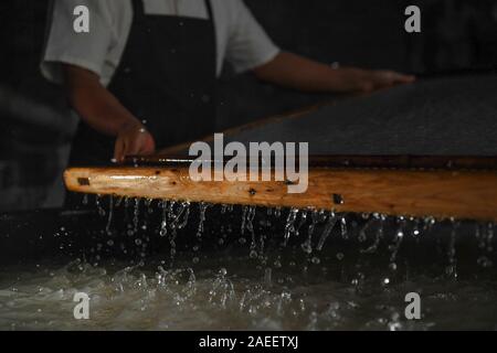 (191209) - JINGXIAN, Dez. 9, 2019 (Xinhua) - Cao Jianqin macht Xuan Papier an der Zijinlou Xuan Papier Fabrik in Jingxian Grafschaft, Stadt Xuancheng der ostchinesischen Provinz Anhui, Okt. 22, 2019. Xuan Papier, traditionelle Chinesische Papier in Jingxian Grafschaft Xuancheng Stadt gemacht, hat eine Geschichte von mehr als 1.000 Jahren. Durch über 100 Verfahren, der das Papier kostet mindestens ein Jahr das Material in das endgültige Produkt zu machen. Für den "Distinguished Handwerk bekannt, feine Qualität und lange Zeit zu bewahren, das Papier ist von chinesischen Künstlern und Kalligraphen geliebt und heißt 'Papier mit li Stockfoto