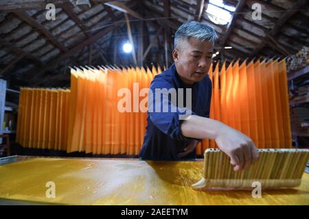 (191209) - JINGXIAN, Dez. 9, 2019 (Xinhua) - Cao Jianqin macht Xuan Papier an der Zijinlou Xuan Papier Fabrik in Jingxian Grafschaft, Stadt Xuancheng der ostchinesischen Provinz Anhui, Okt. 22, 2019. Xuan Papier, traditionelle Chinesische Papier in Jingxian Grafschaft Xuancheng Stadt gemacht, hat eine Geschichte von mehr als 1.000 Jahren. Durch über 100 Verfahren, der das Papier kostet mindestens ein Jahr das Material in das endgültige Produkt zu machen. Für den "Distinguished Handwerk bekannt, feine Qualität und lange Zeit zu bewahren, das Papier ist von chinesischen Künstlern und Kalligraphen geliebt und heißt 'Papier mit li Stockfoto