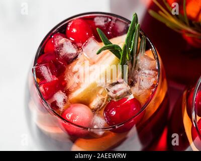 Winter Sangria auf der Tischplatte mit grau Leinen Tischdecke. Gläser Sangria mit Obst schneiden, Cranberry und Rosmarin. Kopieren Sie Platz für Text oder Design. Horizontale. Top View oder flach. Stockfoto