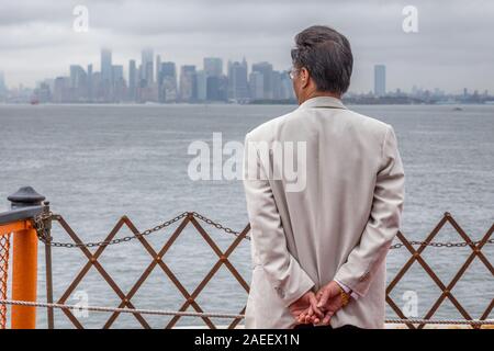 Älterer Herr und die Aussicht genießen, während Sie Musik hören auf orange Fähre von Staten Island nach New York City an nebligen Tag. Stockfoto