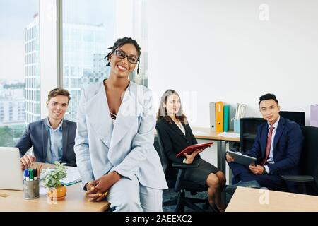 Lächelnd schöne business lady und ihren jungen erfolgreichen Team arbeiten im Büro auf großes Projekt Stockfoto