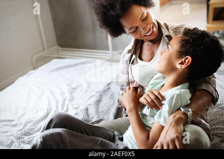 Glückliche Mutter spielen, Spaß haben, umarmen, mit ihrem Sohn zu Hause Stockfoto