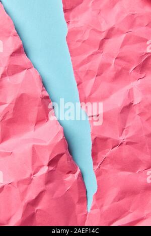 Zerknitterte rosa Papier auf einem Pastell blau als Handwerk dekorative Hintergrund für Ihre Kreativität mit Platz für Text. Stockfoto