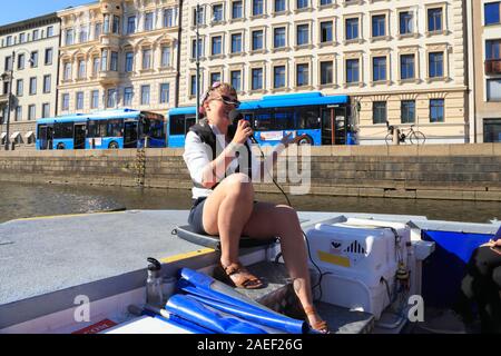 Ein Reiseleiter spricht in einem Mikrofon und bietet Informationen für Touristen auf dem Schiff Mesopotamien in Göteborg, Schweden, im Sommer. Stockfoto