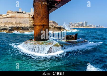 Türkisfarbenen Wellen des Mittelmeers sind Absturz in die Metallhalterung von St Elmo Brücke in Malta, Valletta. Stockfoto