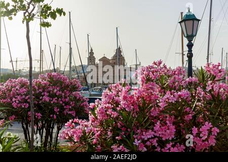Schöne Sicht auf die katholische Kirche auf dem Hintergrund des blauen Himmels. Erstaunlich Stadtbild mit alten Häusern und traditionellen luzzus im Hafen. Stockfoto