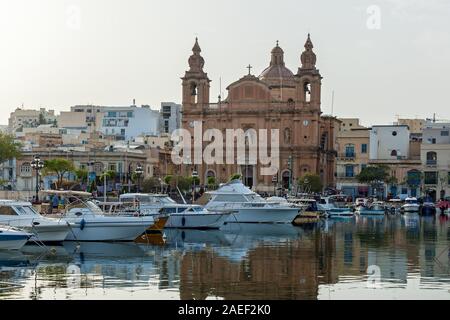 Schöne Sicht auf die katholische Kirche auf dem Hintergrund des blauen Himmels. Erstaunlich Stadtbild mit alten Häusern und traditionellen luzzus im Hafen. Stockfoto