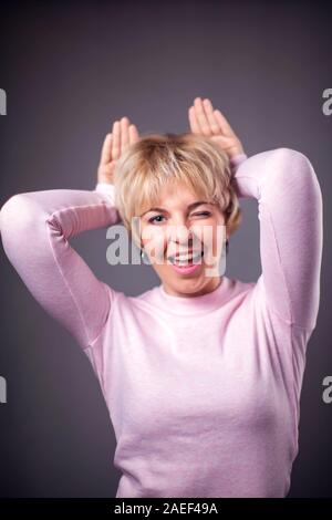 Frau mit kurzen blonden Haaren, die Ohren Geste. Menschen und Emotionen Konzept Stockfoto