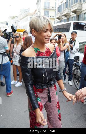 Mailand, Italien - 20 SEPTEMBER 2019: Frau mit schwarzer Lederjacke und geblümten Kleid vor Blumarine Mode zeigen, Mailand Fashion Week street style Stockfoto