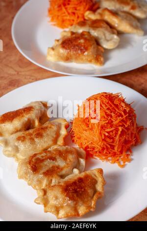 Polnische Teigtaschen mit karottensalat. Knödel gebraten in Gold. Polnischen Köstlichkeiten. Europa Polen. Stockfoto