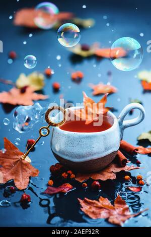 Seifenblasen im Herbst noch Leben mit einem Keramik Teetasse und einer Blase Zauberstab Stockfoto