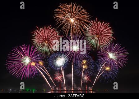 Echten Fireworks Festival in den Himmel für die Feier in der Nacht über das Meer an der Küste für Silvester Countdown feier Hintergrund Stockfoto