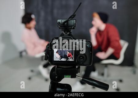 Bildschirm für digitale Video Kamera mit zwei vloggers Sitzen auf Stühlen und Reden Stockfoto
